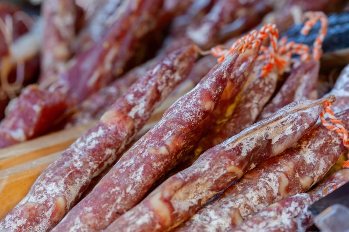 Flour-dusted dry salami links tied with butcher string